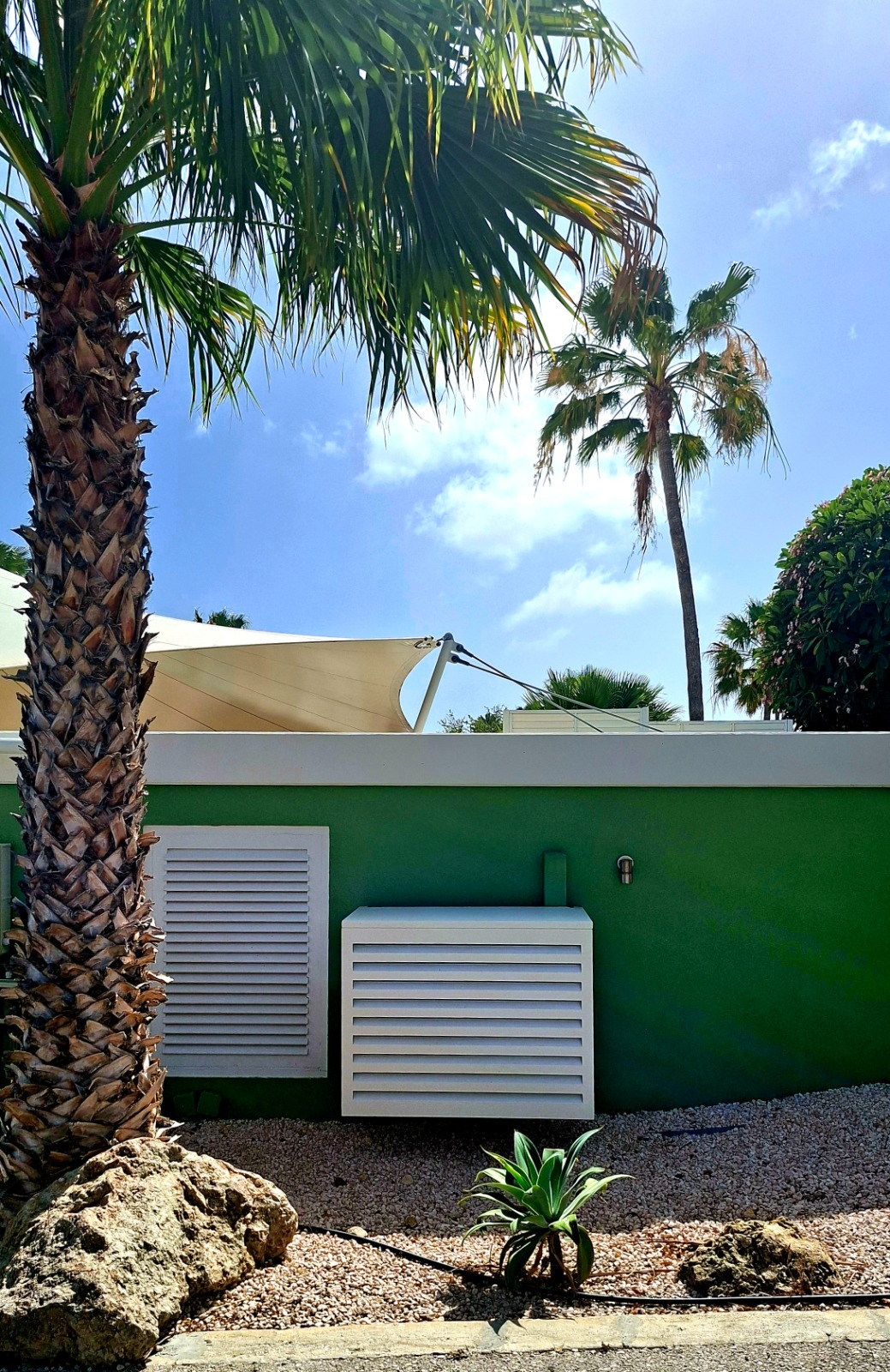 UnderCovers aluminum AC cover installation at a Curacao home